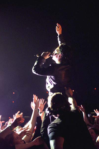 Fans reach out to Bono as he gets near the crowd during U2's show at the Saddledome on Monday, April 9 (Darren Makowichuk, Calgary Sun).