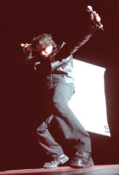 Bono playfully carries a white U2 banner given to him by a fan during April 10's Saddledome show, carrying it as if it were an enormous burden. He became notorious in the early '80s for waving flags at concerts (Darren Makowichuk, Calgary Sun).