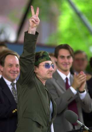U2's Bono gestures with the peace sign after delivering the Class Day address at commencement week ceremonies at Harvard University in Cambridge, Mass., Wednesday, June 6, 2001. At far left is Dean of Harvard College, Harry Lewis. (AP Photo/Elise Amendola)