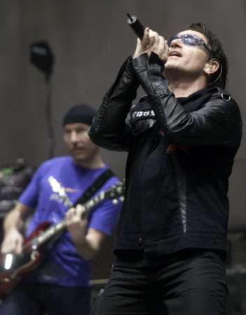 With band member Edge in the background, Bono of the group U2 performs at the Baltimore Arena in Baltimore, Maryland October 19, 2001. Bono and Edge will be joining many other performers at the "Concert for New York City," to be held at Madison Square Garden in New York on October 20. REUTERS/Molly Riley 