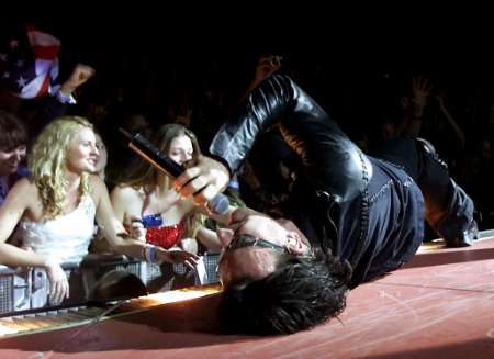 U2 singer Bono rolls around on a catwalk as he sings during a sold-out stop of the band's Elevation Tour at the Thomas & Mack Center in Las Vegas November 18, 2001. The band is touring to support the album "All That You Can't Leave Behind." REUTERS/ Ethan Miller/Las Vegas Sun