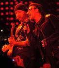 Red light bathes U2 singer Bono, right, as he sings with The Edge, left, during the first concert of their Vertigo Tour at the San Diego Sports Arena Monday, March 28, 2005. (AP Photo/Denis Poroy)