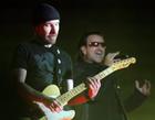 Singer of Irish rockband U2, Bono, performs behind guitarist The Edge, left, in front of 60,000 fans at the Arena AufSchalke in Gelsenkirchen, Germany, Sunday, June 12, 2005. The concert is the first in Germany and the second concert in Europe of U2's Vertigo tour. (AP Photo/Martin Meissner)