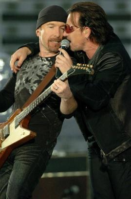 Bono, right, leans on guitarist The Edge as U2 perform their second song 'I Will Follow' at Croke Park stadium in Dublin, Ireland Friday June 24, 2005. (AP Photo/ Haydn West/PA)