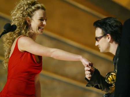 Bono (R) from U2 kisses the hand of presenter Britney Spears as he accepts the Grammy Award for Best Pop Performance by a Duo or Group at the 44th Annual Grammy Awards in Los Angeles February 27, 2002. U2 won for their song "Stuck in a Moment you Can't Get Out Of." REUTERS/Gary Hershorn