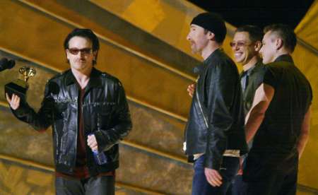 U2 members Bono (L), The Edge (C), Adam Clayton and Larry Mullen (R) accept the Grammy Award for Best Performance by a Duo or Group at the 44th Annual Grammy Awards in Los Angeles February 27, 2002. U2 won for their song "Stuck in a Moment you Can't Get Out Of." REUTERS/Gary Hershorn