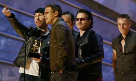U2 members (L-R), The Edge, Adam Clayton, Bono and Larry Mullen, accept the Grammy Award for Record of the Year at the 44th Annual Grammy Awards in Los Angeles February 27, 2002. U2 won for their song "Walk On." REUTERS/Gary Hershorn