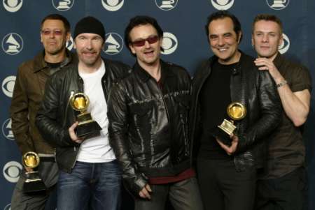 The Irish rock group U2, (L-R) The Edge, Adam Clayton, Bono, producer Daniel Lanois and Larry Mullen, pose after winning five Grammy Awards at the 44th annual Grammy Awards February 27, 2002 in Los Angeles. The awards included Record of the Year for "Walk On," Best Rock Performance by a Duo or Group with Vocal for " Elevation" and Best Rock Album for "All That You Can't Leave Behind." REUTERS/Mike Blake